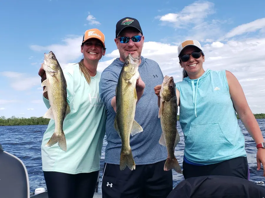 Family holding walleyes during a guided northern Minnesota fishing trip