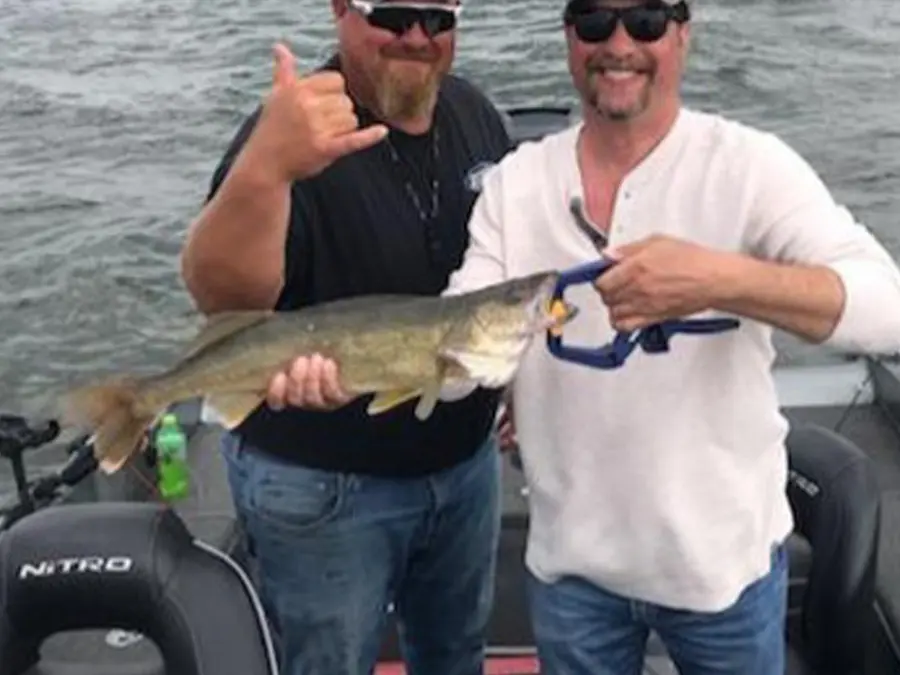 Scott Zupfer and a guest holding a walleye during a northern Minnesota guided fishing trip